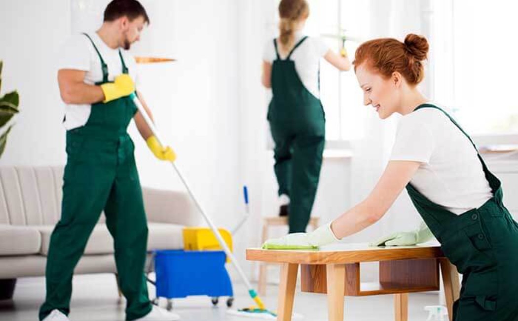 Cleaning team sanitizing furniture and mopping a bright rental property for Airbnb Cleaning Services.
