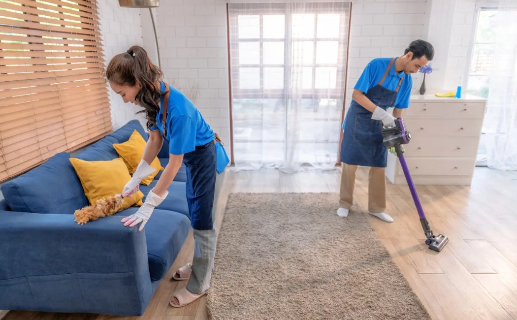 Expert Cleaning Services for a Fresh Home. Cleaning Services experts deep cleaning a living room by dusting furniture, vacuuming floors, and maintaining a fresh, spotless home environment.