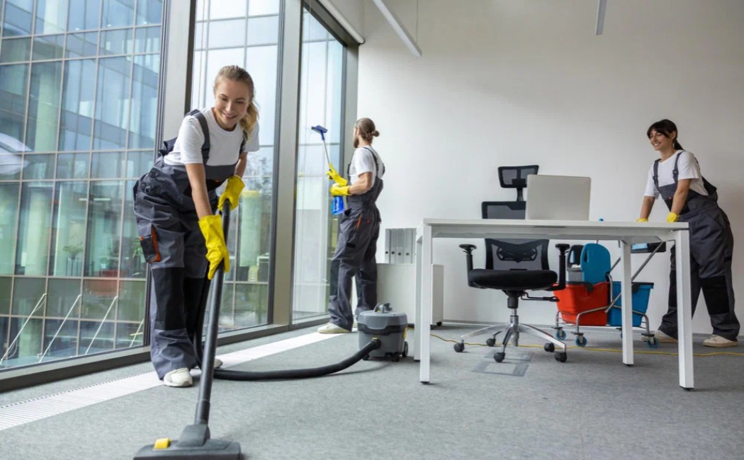 Cleaning Services team vacuuming floors, cleaning windows, and sanitizing a modern office workspace for a spotless and professional environment.