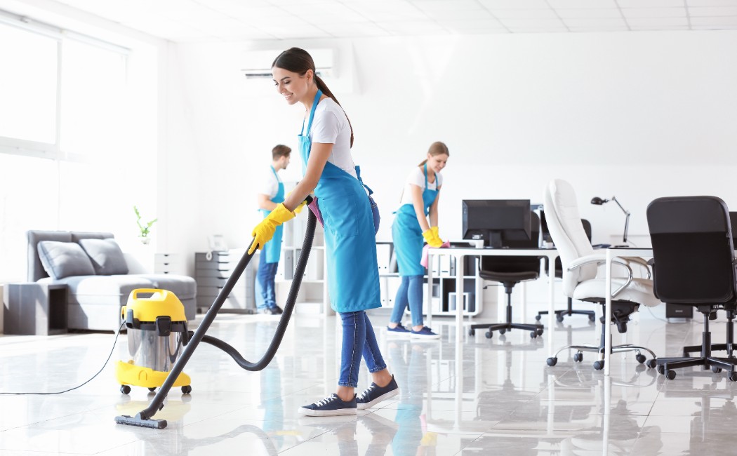 Commercial Cleaning Services for Modern Offices. Cleaning Services professionals vacuuming floors and sanitizing workstations in a bright modern office to maintain a clean and productive environment.