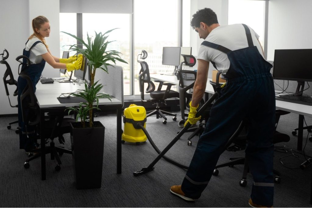 Professional Office Cleaning Services team vacuuming carpets and disinfecting office workstations for a spotless, healthy, and productive workspace.