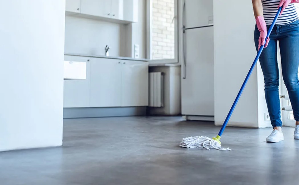 Airbnb cleaning professional mopping the floor of a modern rental property to ensure a spotless and guest-ready space.