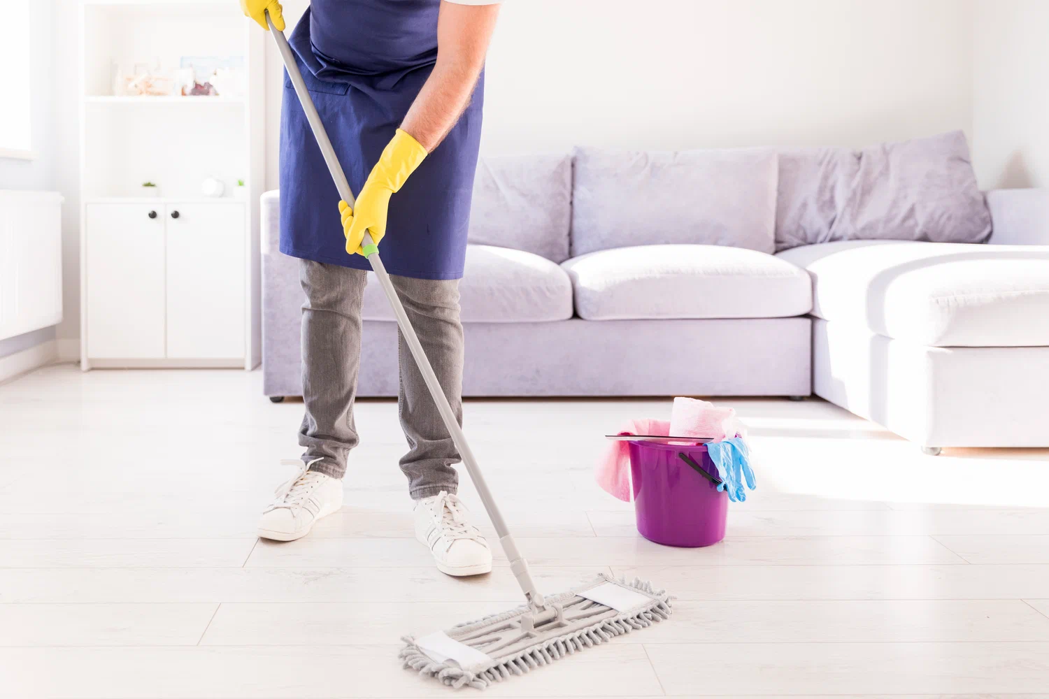 Home Cleaning expert mopping a bright living room floor for a fresh, spotless, and inviting space.