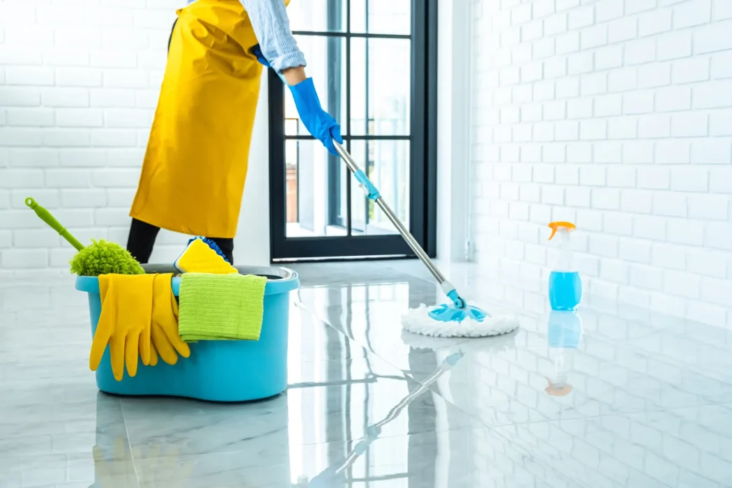 Cleaning Service professional mopping a spotless floor with eco-friendly cleaning supplies in a bright, modern home.