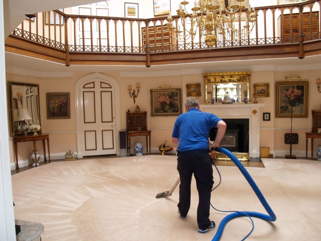 A residential cleaning professional deep-cleans a luxurious home’s carpet, restoring freshness and a spotless, inviting living space.