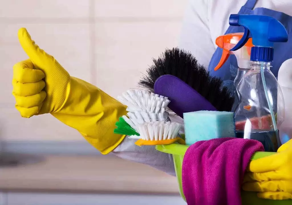 House Cleaning essentials including gloves, scrub brushes, sponges, and cleaning sprays for a tidy home.